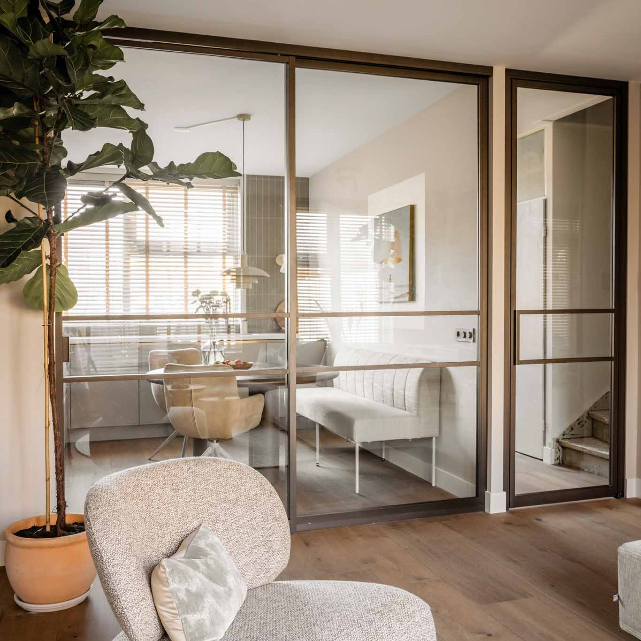 vtwonen woonkamer met roomdivider en bronzen deur van GewoonGers