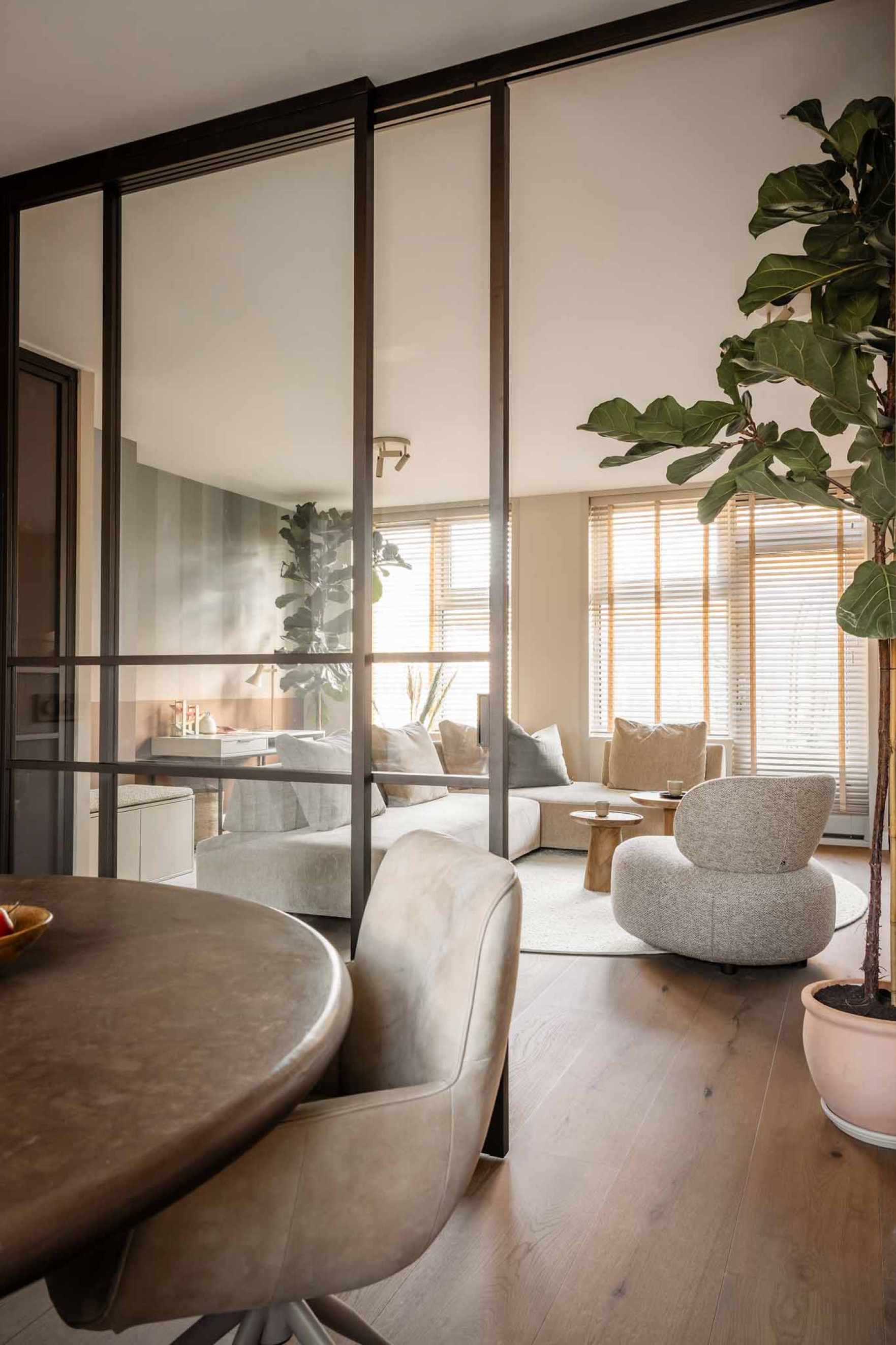 vtwonen woonkamer met roomdivider en bronzen deur van GewoonGers