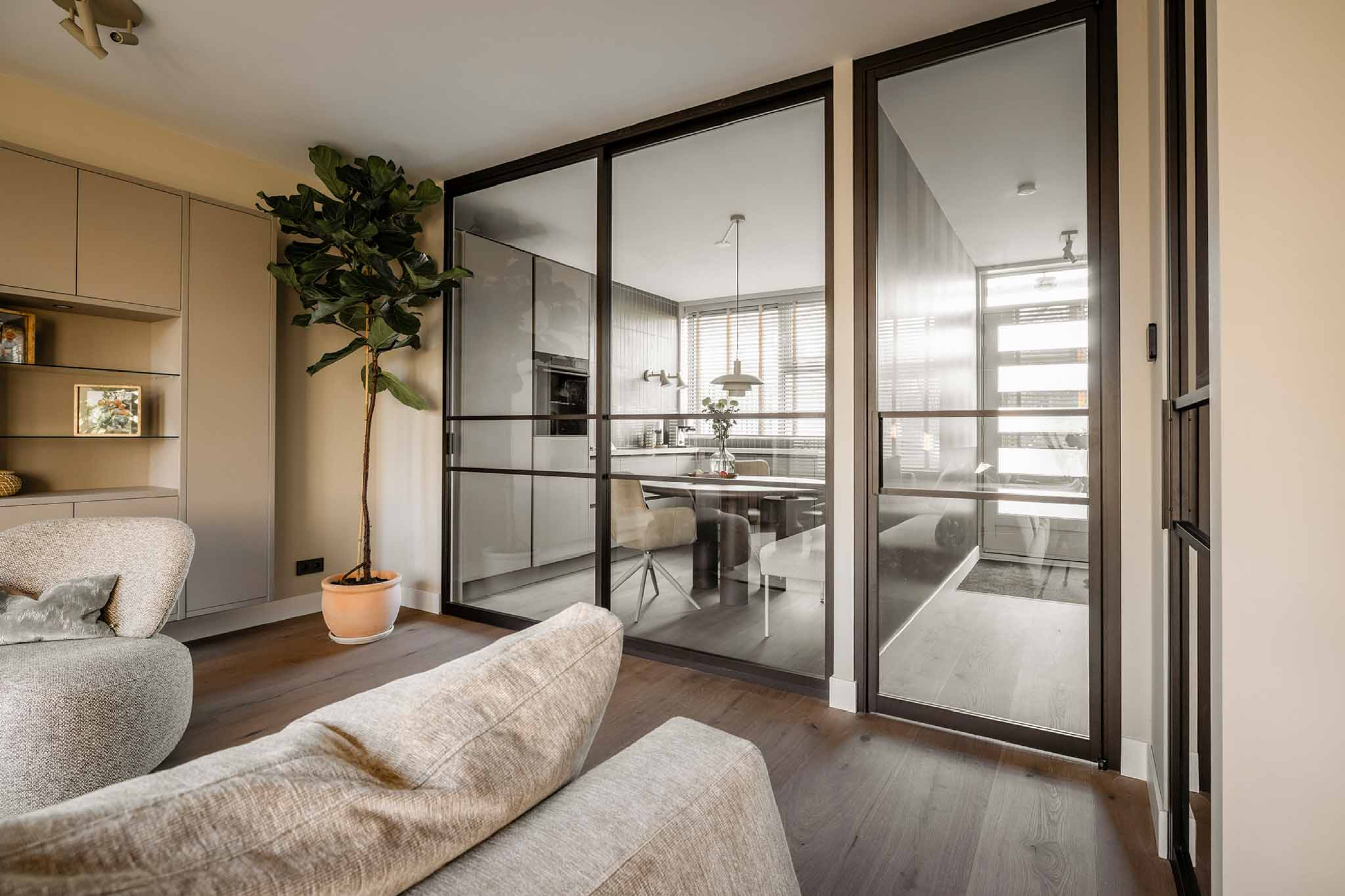 vtwonen woonkamer met roomdivider en bronzen deur van GewoonGers