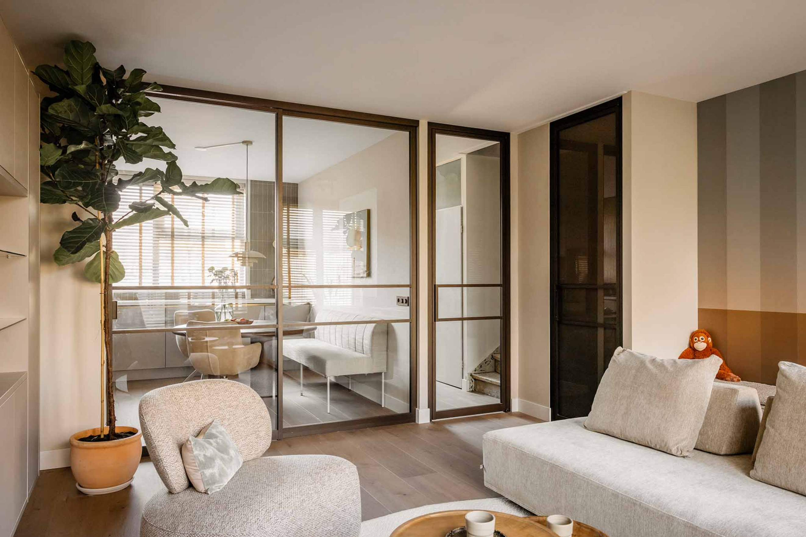 vtwonen woonkamer met roomdivider en bronzen deur van GewoonGers